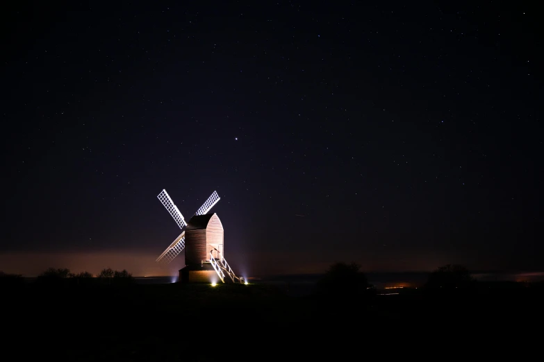 an old windmill sitting in the middle of a field