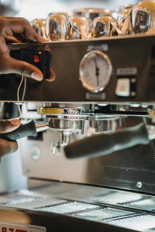 espresso machine being operated by a person working on the lagera