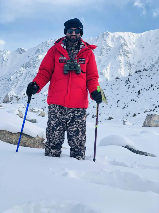 a man on top of a snowy hill holding skis