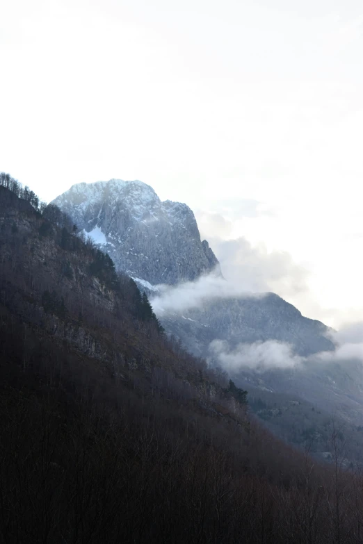 the mountain range in winter with a low lying cloud