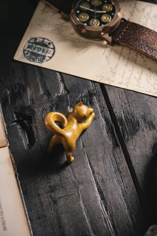 a gold cat sculpture is shown on some wood