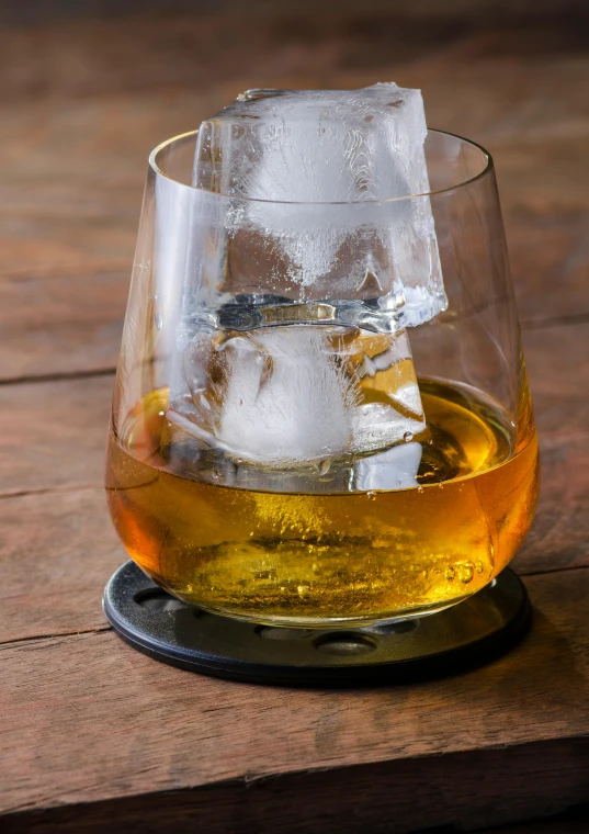 a glass with ice cubes sitting on top of a table