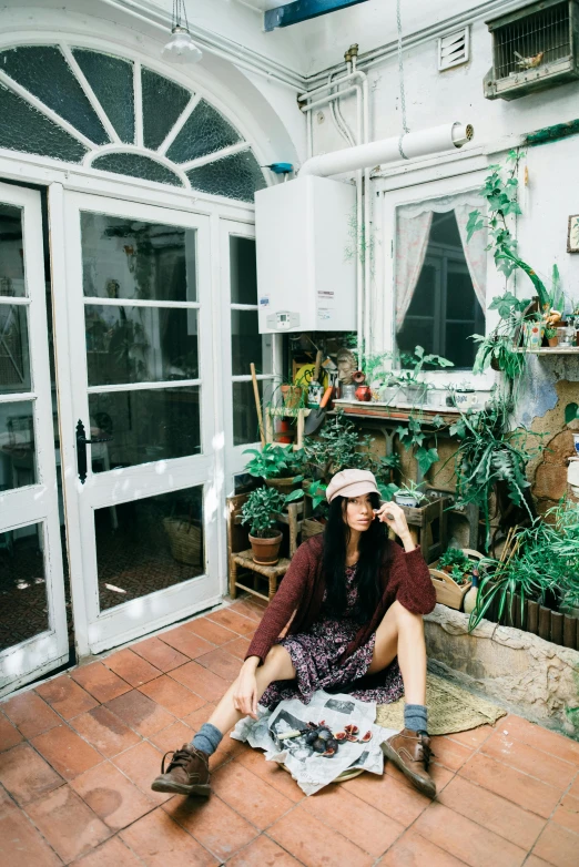 a woman sitting on the ground talking on a cellphone