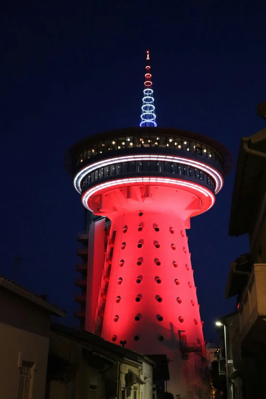 the tower of television on the building lit up at night