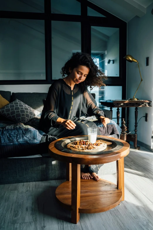 a woman sitting on top of a sofa next to a table