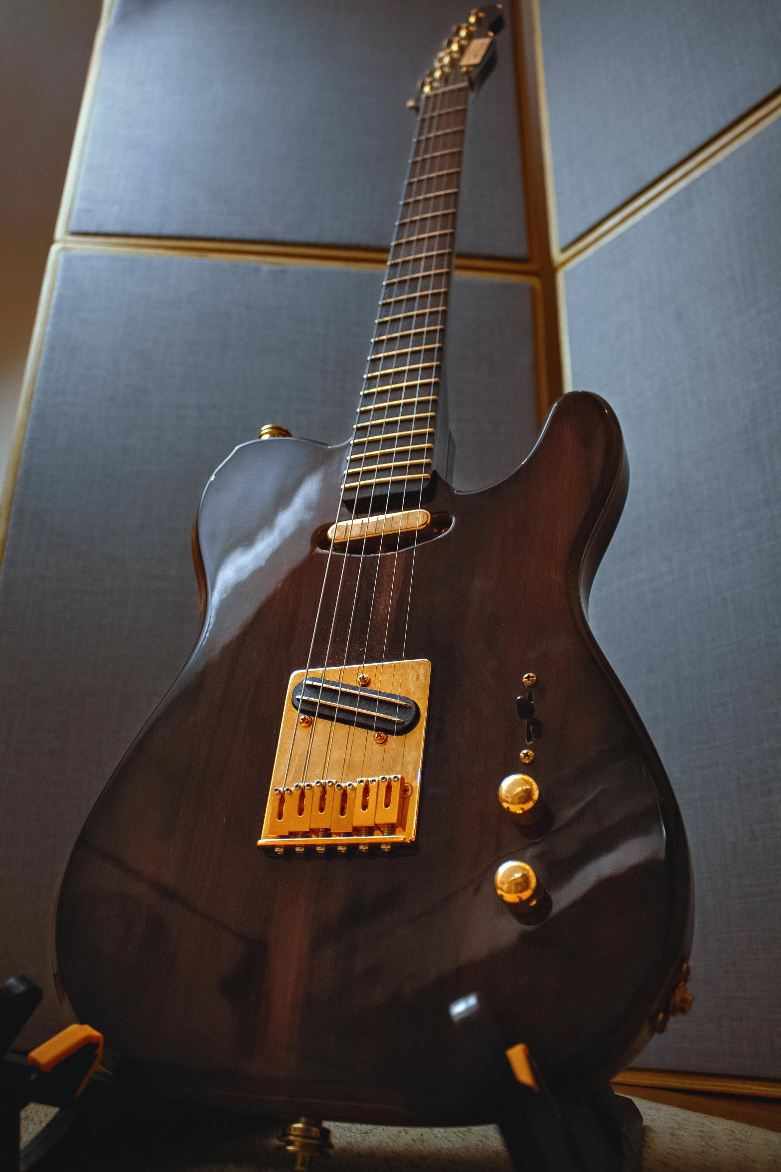 a small acoustic guitar with gold hardware, is on display