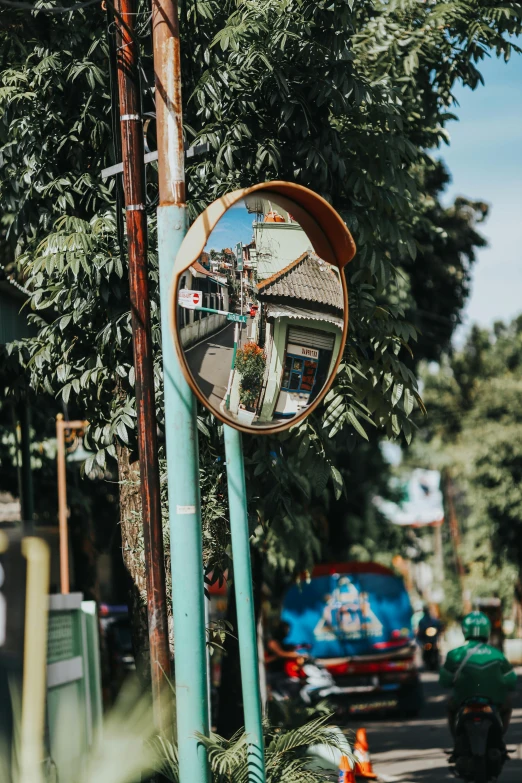 a mirror on the pole in front of a blue pole