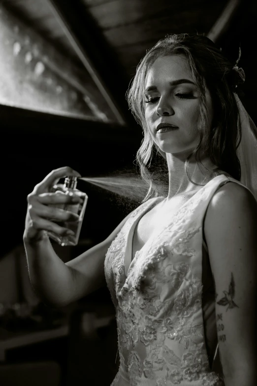 the bride holds her veil and bottle of whiskey