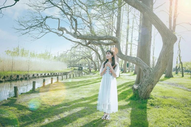 woman in white dress with bird near tree