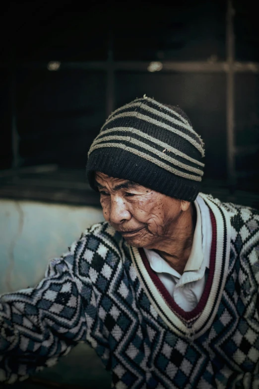 old person sitting in front of a large truck