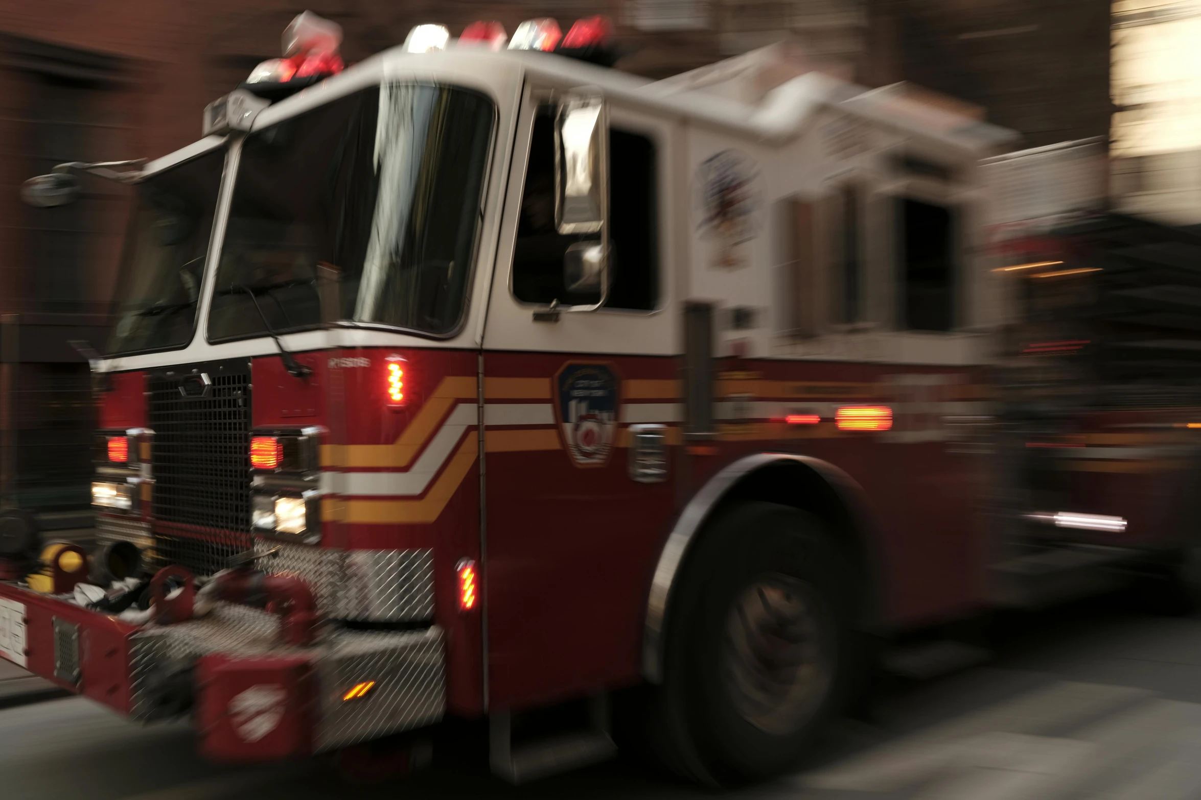 a large red firetruck is driving in the city