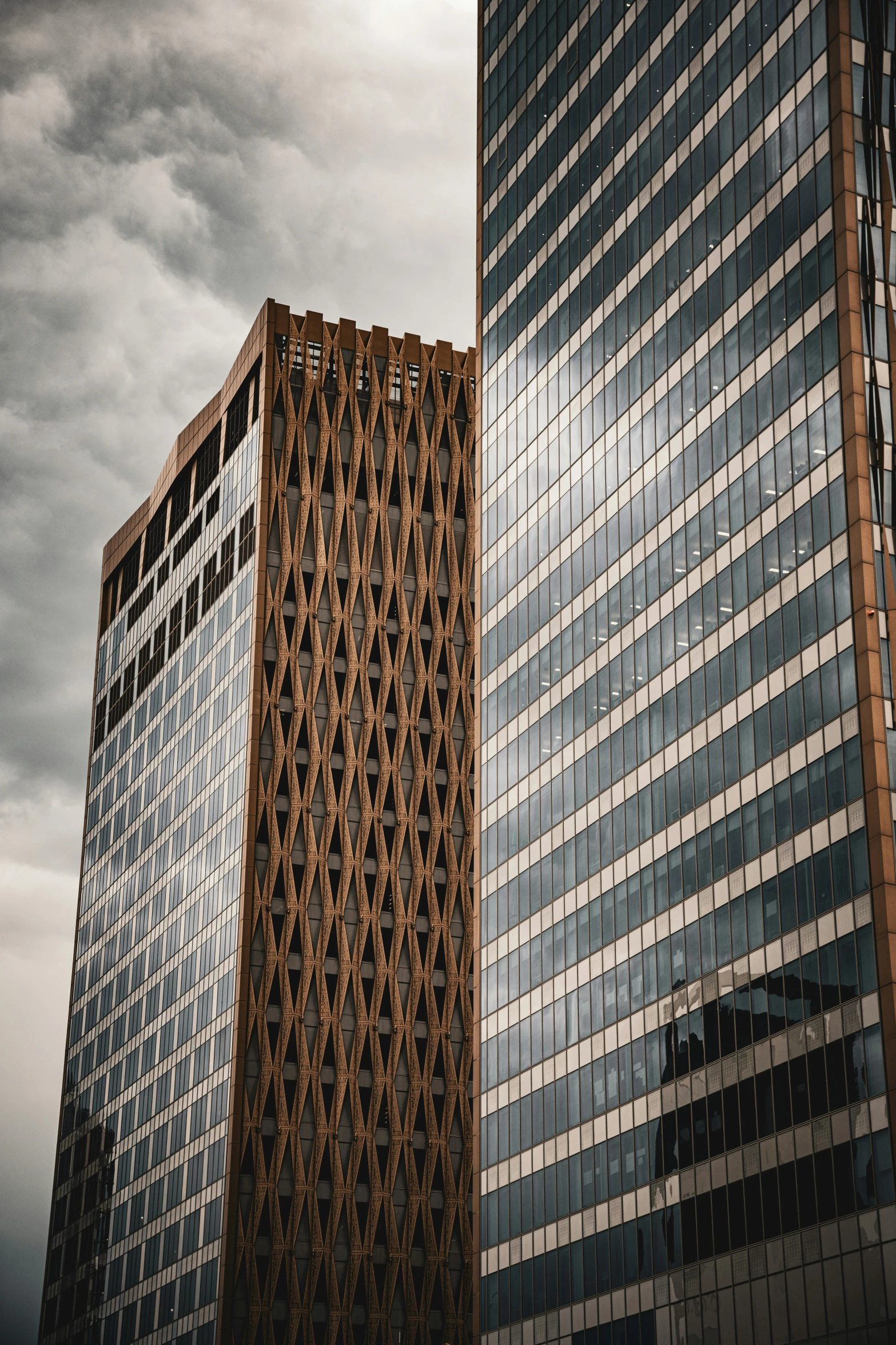 two very tall buildings against the cloudy sky