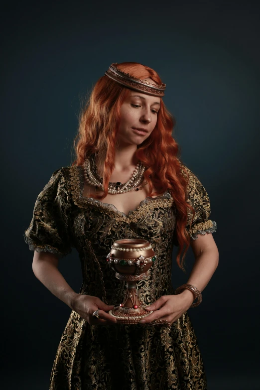 the young woman in a medieval dress is holding a dish