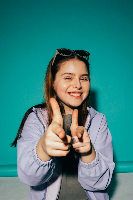  holding up her fingers to make a sign