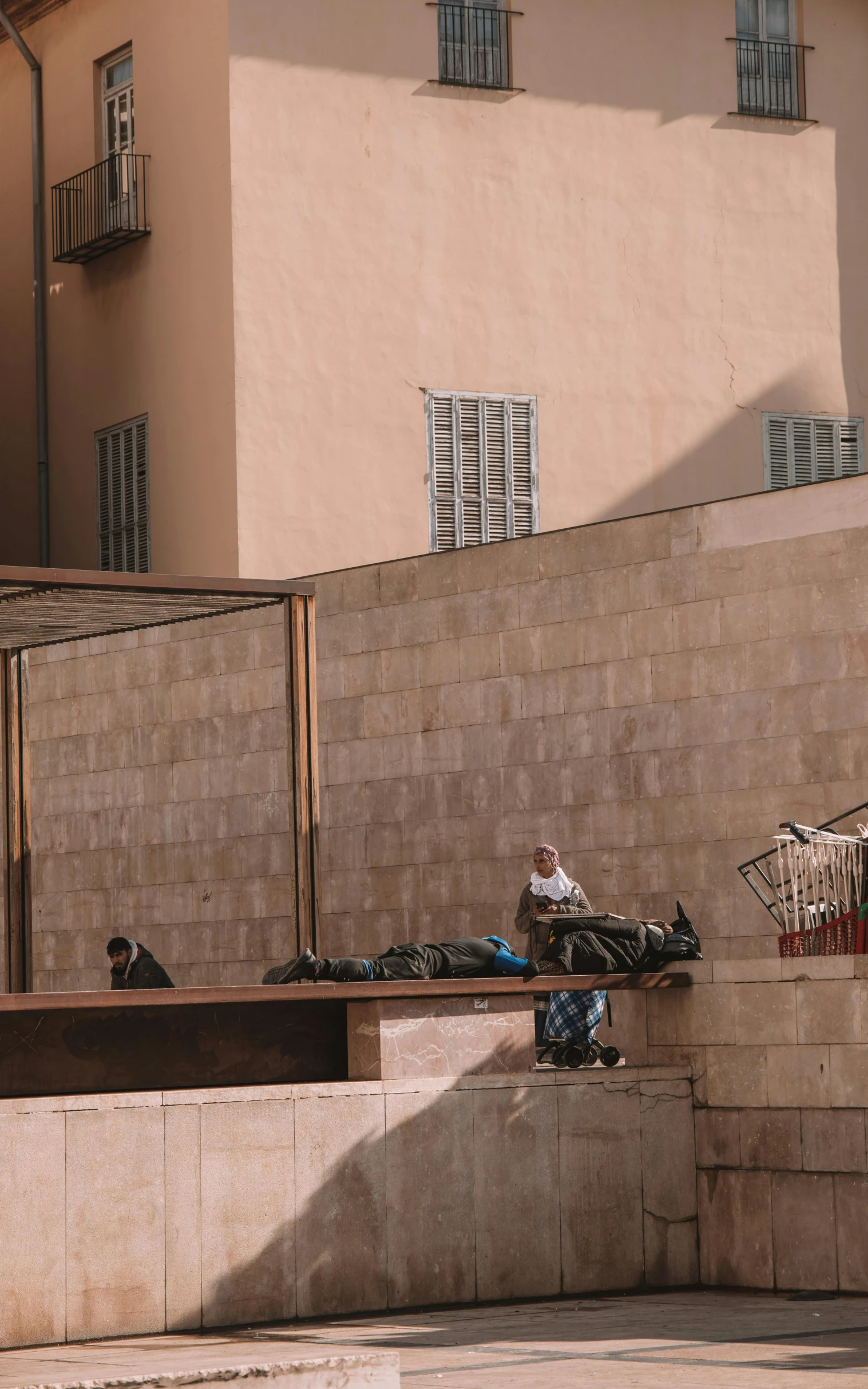 some people sitting in a courtyard in front of buildings