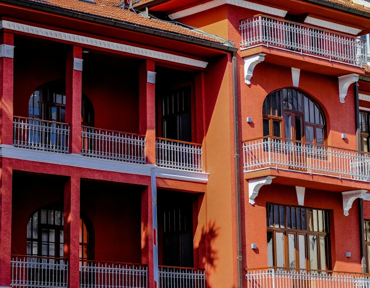 a red building with many balconies with balconies on the balconies