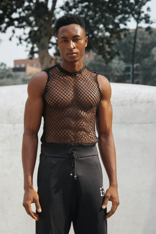 the young man is posing by a concrete wall