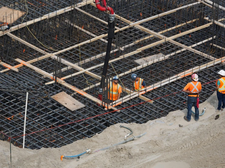 a number of construction workers standing near construction