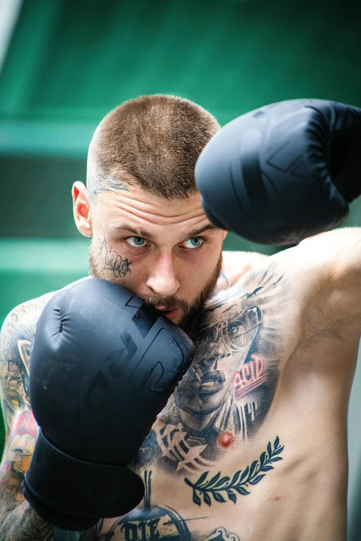 a young man is holding his head up and wearing boxing gloves