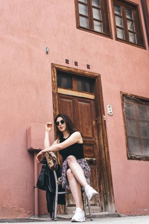 a woman sitting on a chair with a hand bag by a door