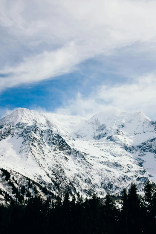 a snowy mountain is covered with clouds and snow