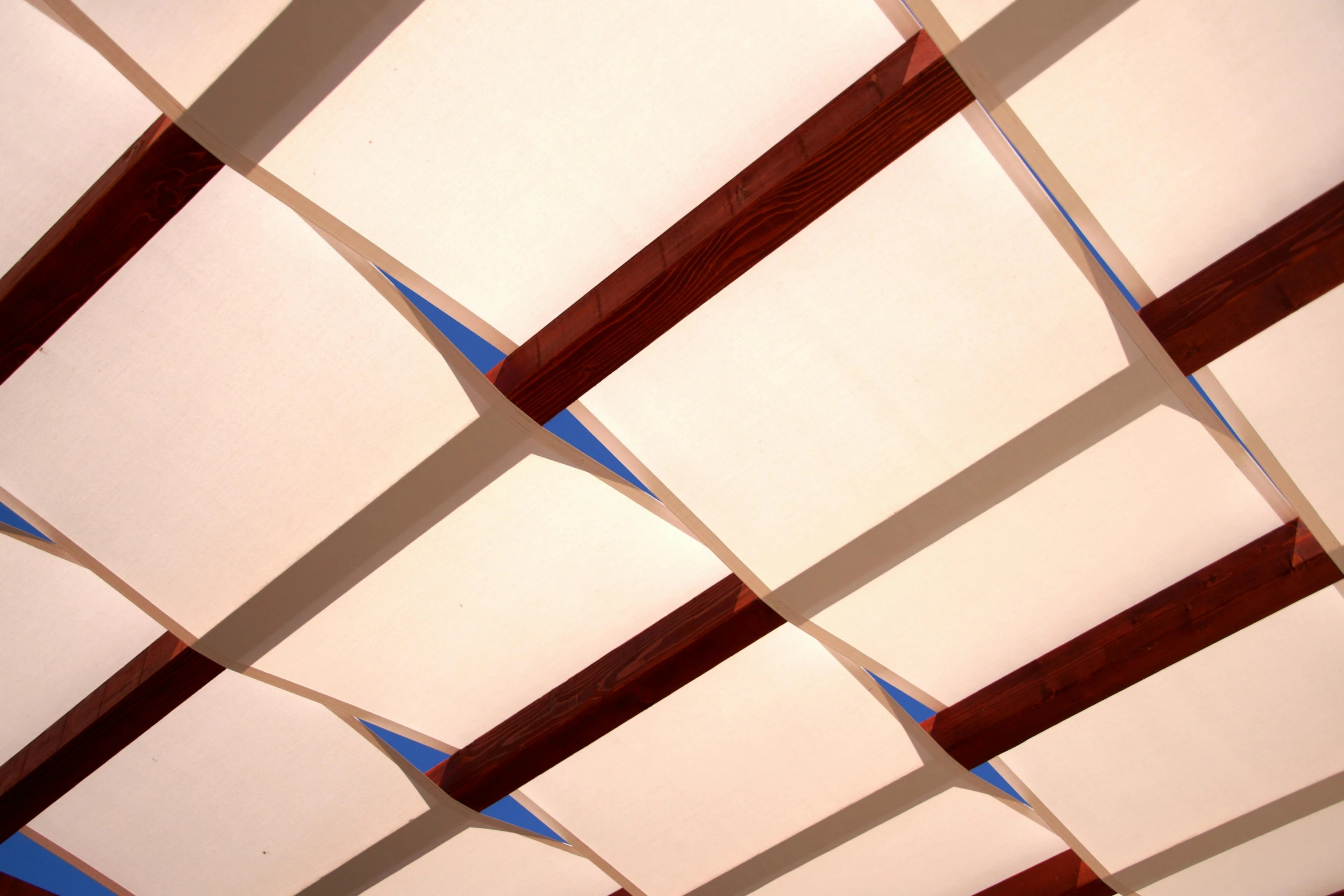 the light is shining on the ceiling with wooden beams