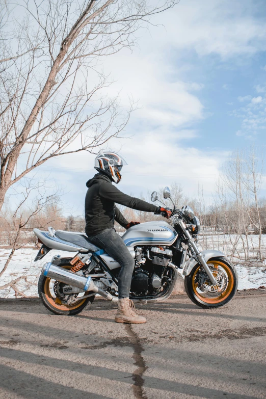 a man riding on the back of a motorcycle down a snow covered road