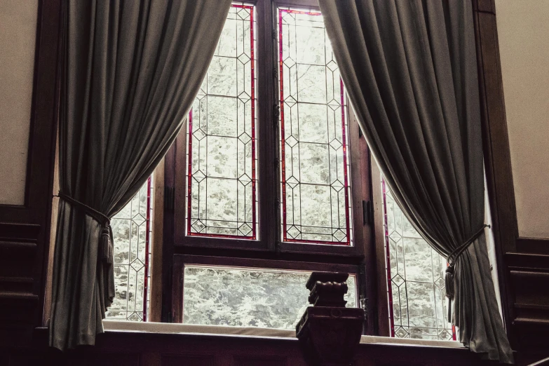 a window in a living room with curtains and a vase