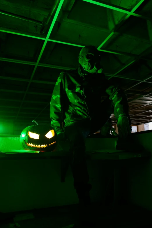 man sitting in garage with flashlight glowing on pumpkin