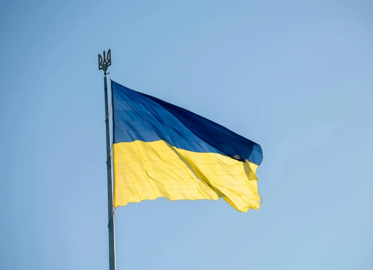 a very large blue and yellow flag on a pole