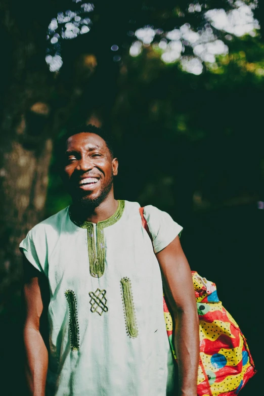 a man smiles with a backpack beside him