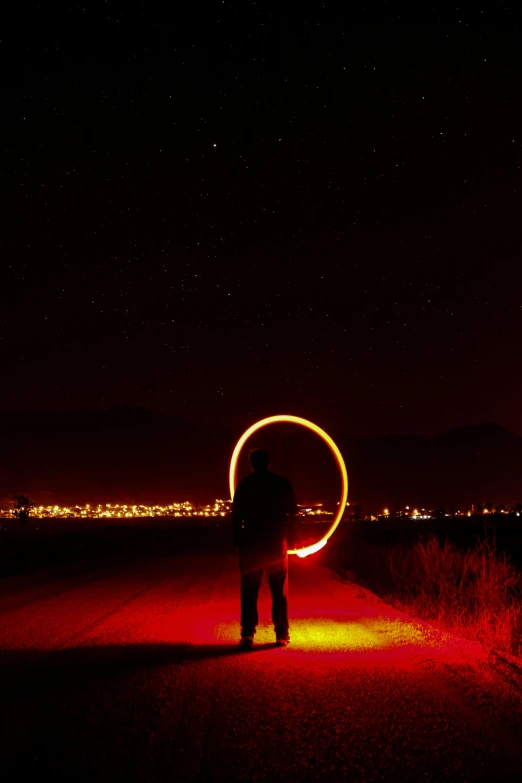 a person standing on a road with a ring in the air