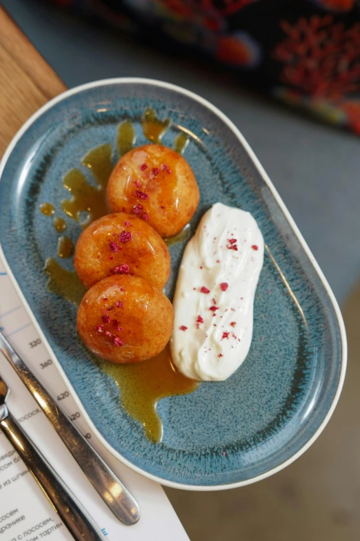 a blue plate with three pieces of doughnuts on it