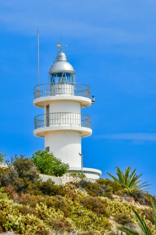 a large white lighthouse sitting on top of a hillside