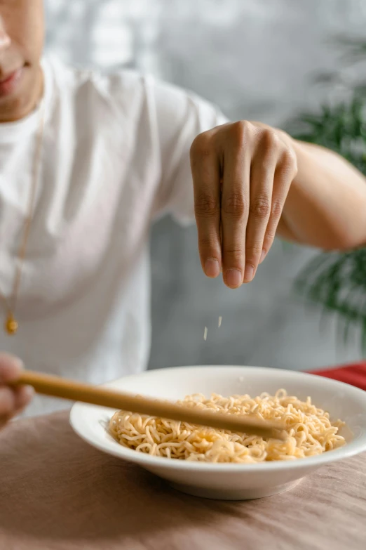 someone adding the rice to their meal with chopsticks