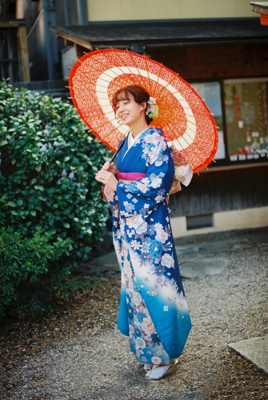 woman dressed in blue dress with orange umbrella