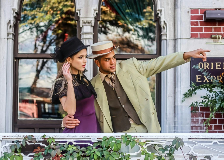 an attractive couple pointing to soing while standing outside of the building