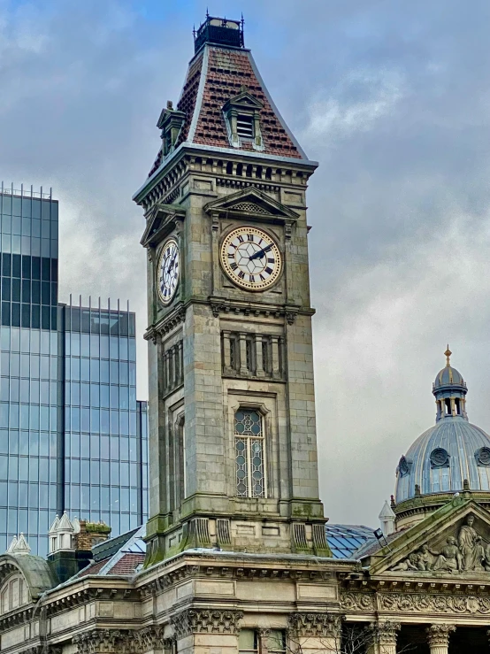 a clock tower stands over the top of some buildings