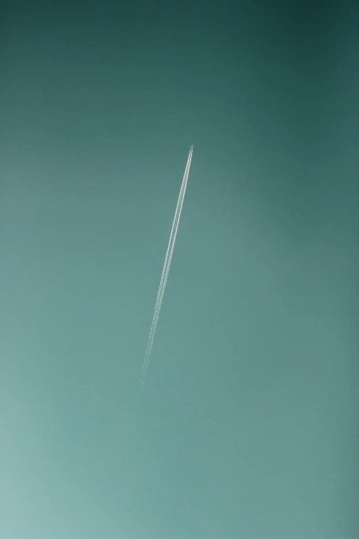 an airplane passing in the sky with contrail trailing