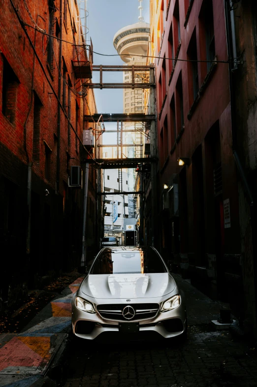 white car in an alleyway with buildings in the background