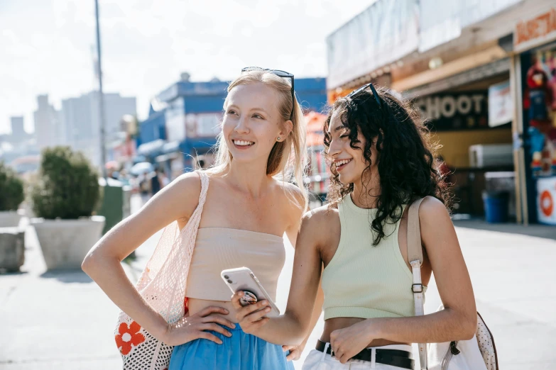 two girls in dresses smiling at each other