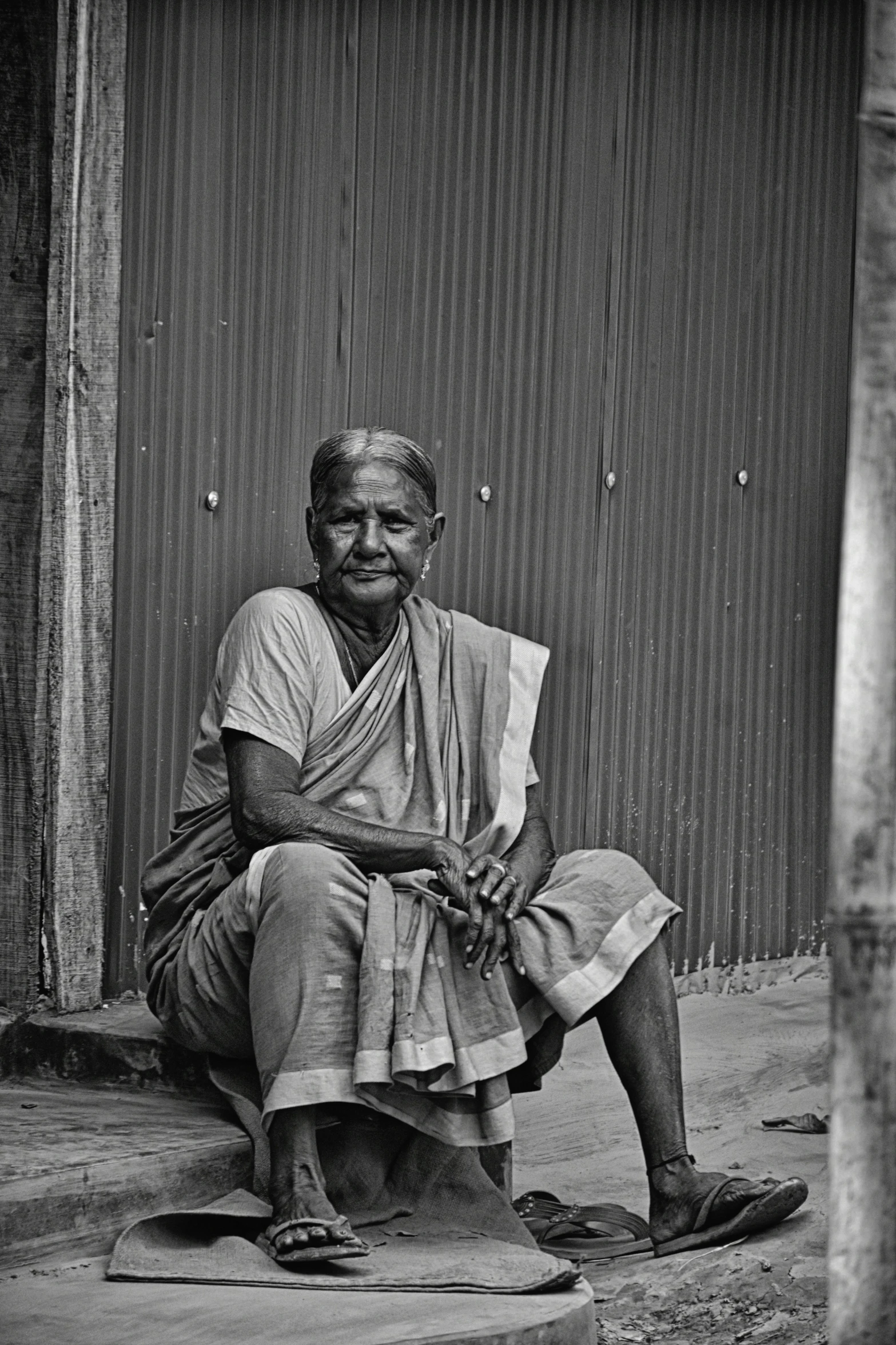 an old man sitting on the sidewalk