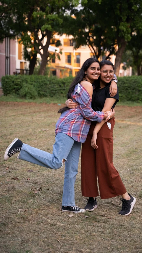 two women in brown and blue hug each other