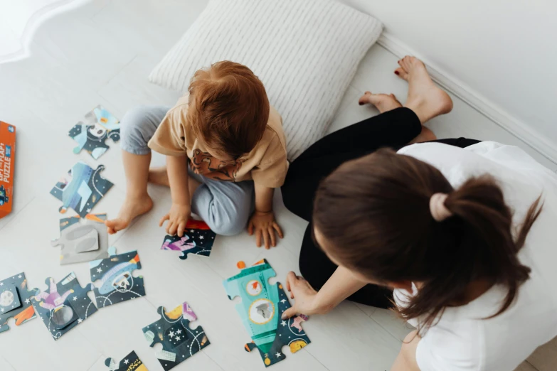 two girls playing with construction toy pieces on the floor