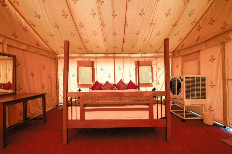 a bed in a large tent with a mirror and a dresser