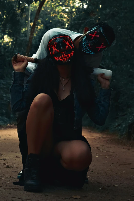 woman squatting down with two glowing masks on