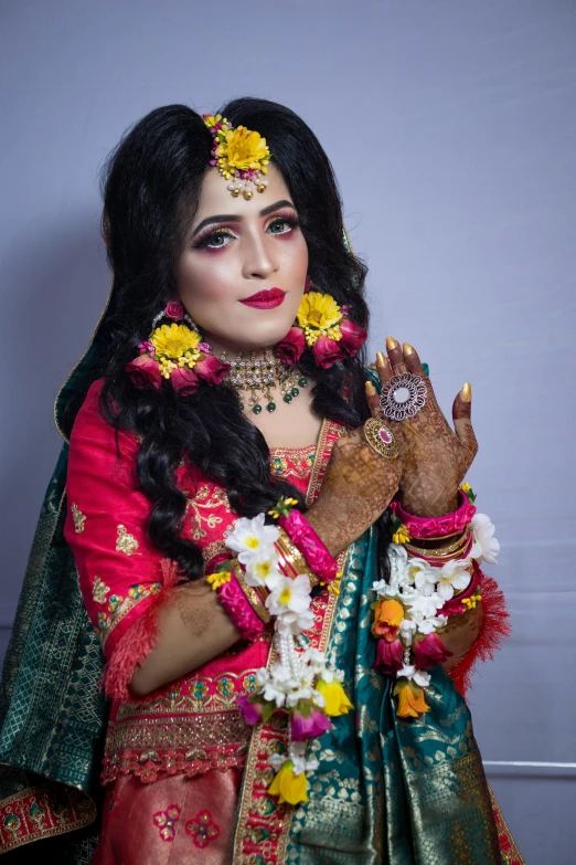 a beautiful indian woman in her colorful sari with flowers