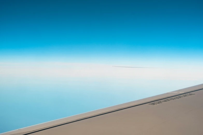 a small airplane wing with some clouds in the background