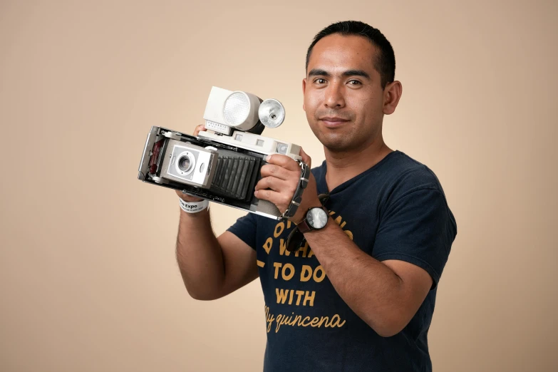 a man is holding a small camera