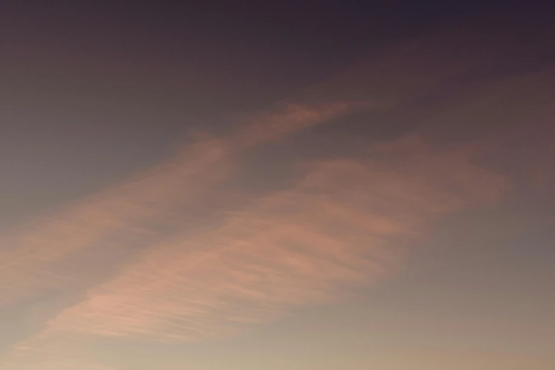 the silhouette of two airplanes with contrails on the sky